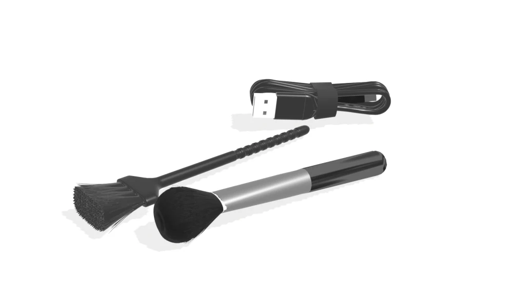 Folded USB-C charging cable with its strap and both plugs, alongside the flat and round cleaning brushes